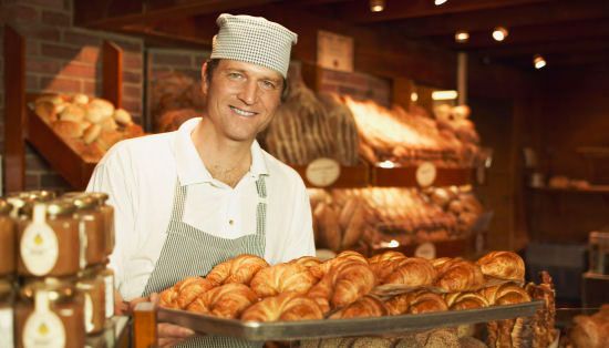 Panadería Bonome panadero sosteniendo panes